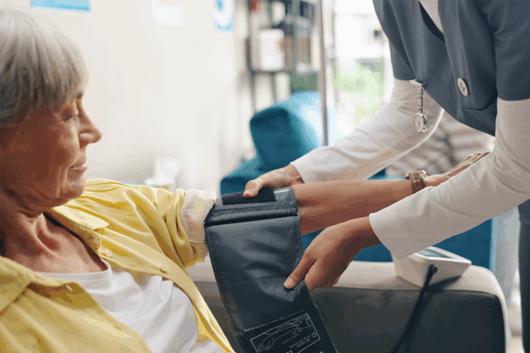 Lähihoitaja mittaa potilaan verenpaineen.