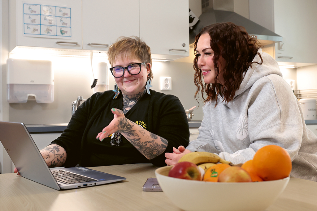 Lähihoitaja Sari Ojala ja sosionomi Milla Kallio tietokoneen ääressä.